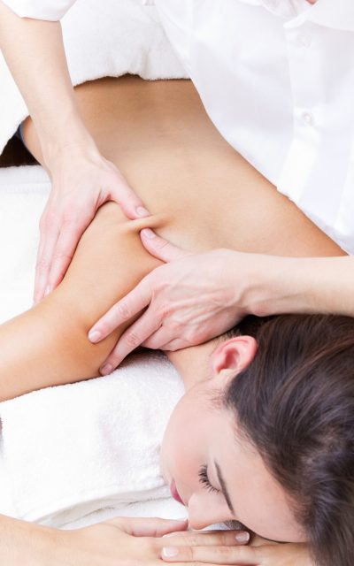 Pretty Woman enjoying shoulder massage at beauty spa