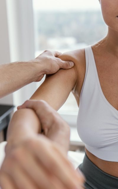 terapeuta-osteopatico-masculino-comprobando-hombro-paciente-femenino